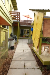 A view of the backyard, with chicken coop on the left and playhouse on the right.